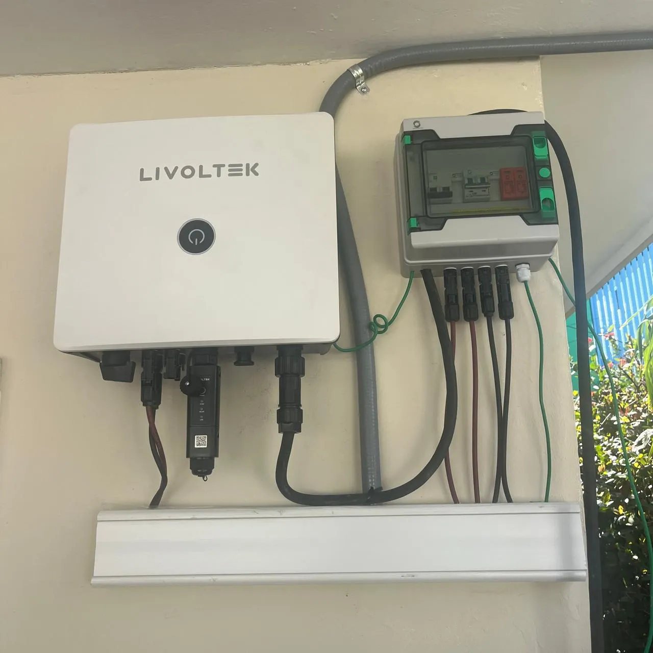 Inversor Livoltek instalado en pared, junto a su interruptor de desconexión