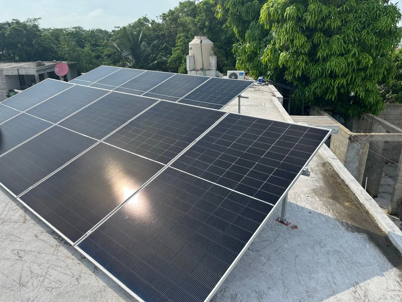 Sistema solar grande instalado en techo de concreto, con vegetación de fondo